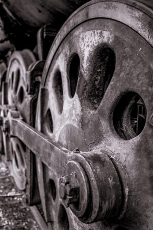 A close-up photograph of an antique train wheel.